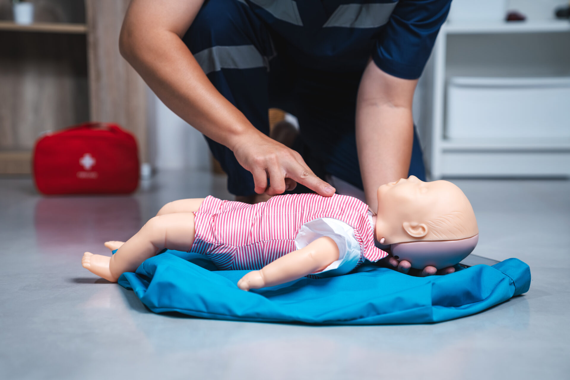 Pediatric First Aid, Two-Finger CPR on Baby Manikin for Emergency Infant CPR Training and Healthcare Education Concept